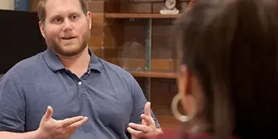 An over the shoulder look from a woman's perspective, with man at a desk talking to her